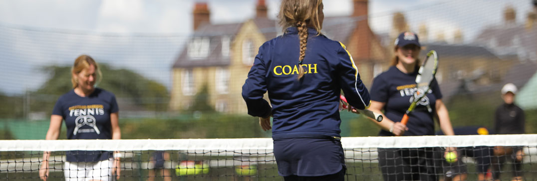 Adult coach at net with players