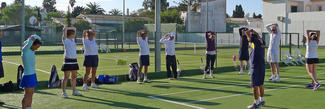 Adults warm down and stretch after tennis