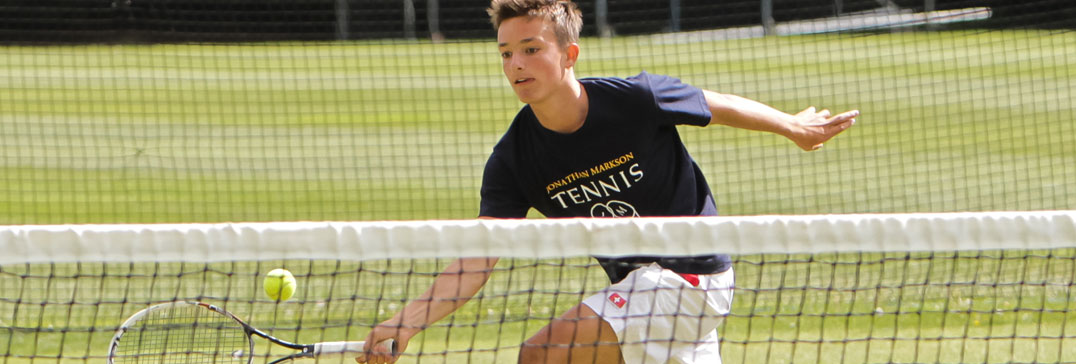 Tennis player at the net on grass courts