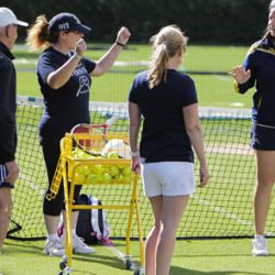 Tennis coach with small adult tennis group